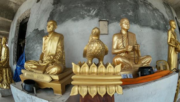 Im unteren Teil der Statue sind viele goldene Buddha-Statuen aufgestellt.